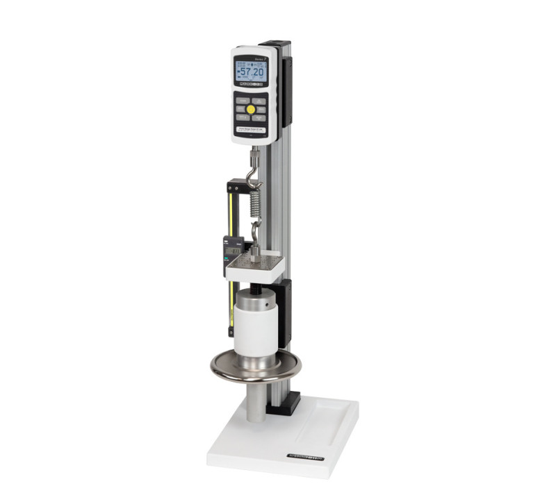 The TSC1000 vertical test stand is shown in a tension spring testing application with a Series 7 digital force gauge, set of hooks, and optional digital travel display.