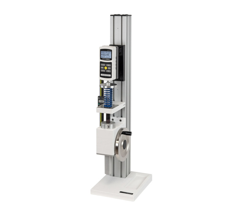 The TSF vertical test stand is shown in a compression spring testing application with Model M7-200 digital force gauge, compression plate, and optional digital travel display.