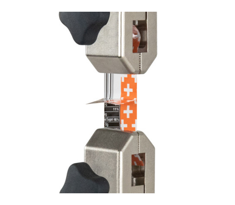 Pair of G1008 grips shown in a typical 180° peel test of a sealed package strip.