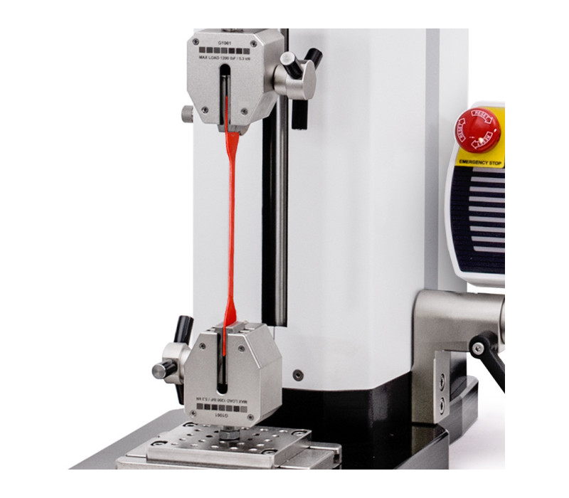 A pair of G1061 grips is shown in a typical tensile testing application, mounted to a test stand and digital force gauge