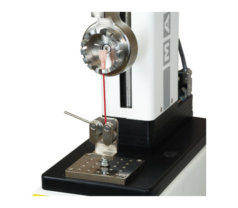 G1076 shown in a typical wire terminal pull testing application, used in conjunction with a digital force gauge, test stand, and G1002 dual roller grip.