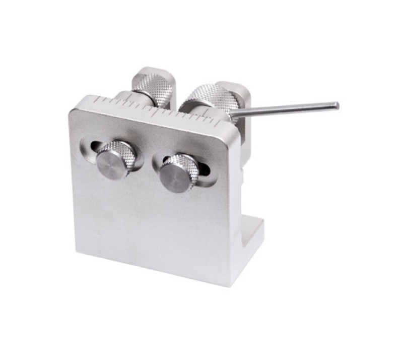 To reposition the cams, loosen the thumb screws in the rear of the housing, slide in either direction, and retighten. Interlocking teeth in the front of the housing ensure the cams are properly positioned for the test. Distance markers are provided for visual convenience.